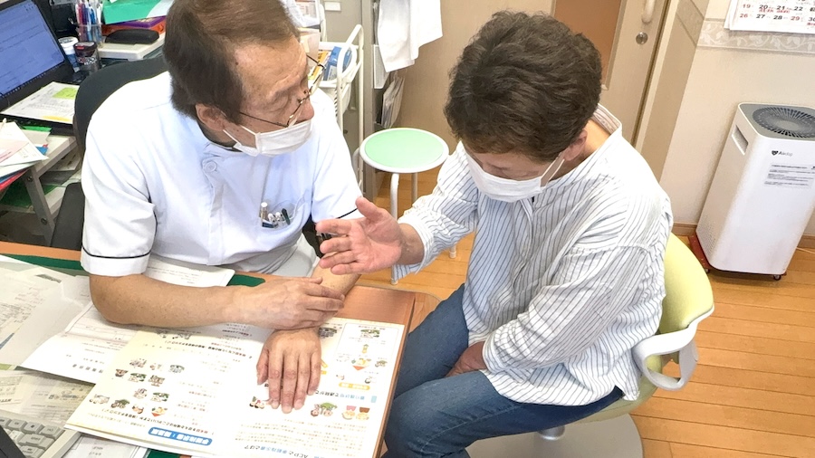 クリニックで診察を行う今出医師